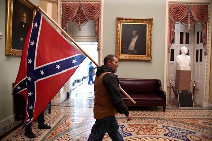 Un partidario del presidente Donald Trump lleva una bandera confederada en el segundo piso del Capitolio de EEUU, cerca de la entrada al Senado después de violar las defensas de seguridad, en Washington DC, EEUU. 6 de enero de 2021. REUTERS/Mike Theiler