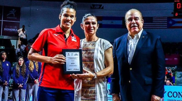 Niverka Marte, de Las Reinas del Caribe, recibe de Ana Guevara el premio de Jugadora Más Valiosa de la Copa Panamericana de Voleibol en presencia de Cristóbal Marte.